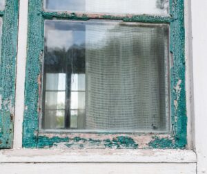 house in poor condition showing an old window needing some paint