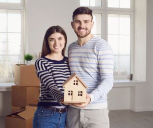 couple stands in living room preparing to sell their home