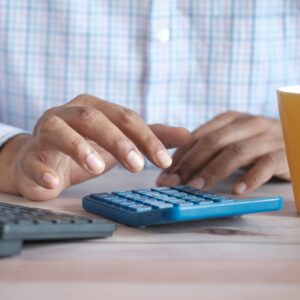 man calculating taxes on calculator